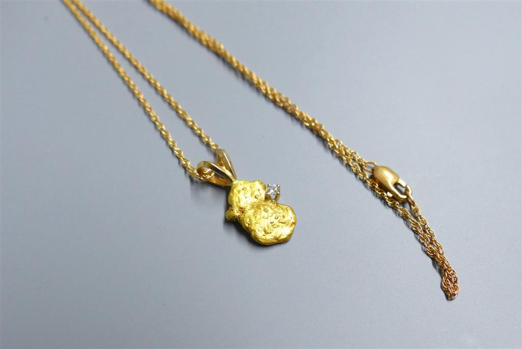 A diamond set gold nugget pendant, 12mm, gross 2.1grams, on a 585 fine link chain, 1.4 grams.